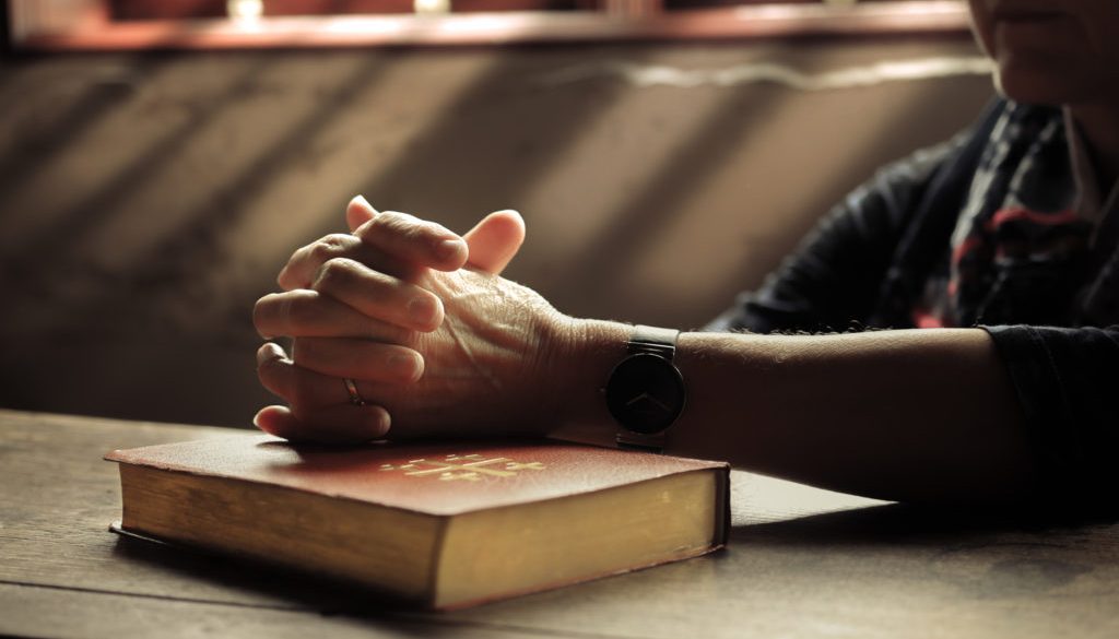 praying-over-a-bible-lightstock_366465